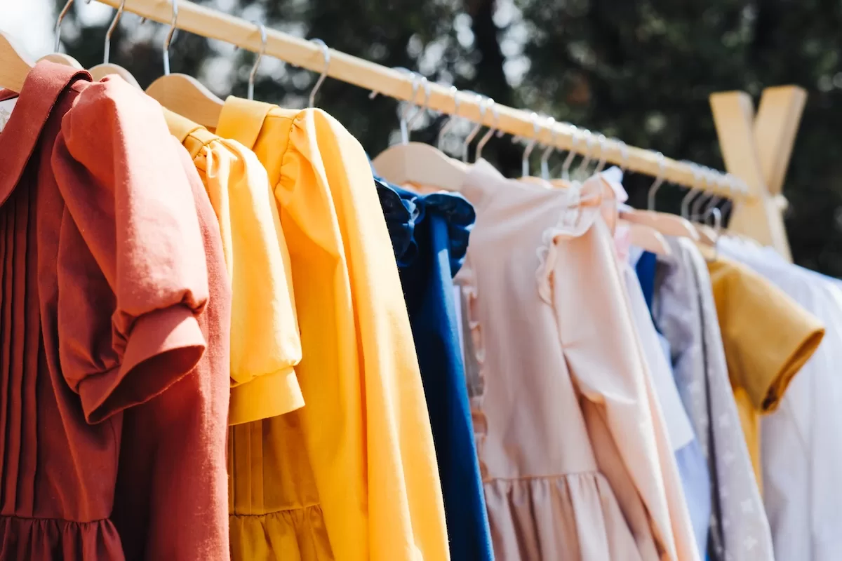 Sale of clothes made of natural fabrics. Children's clothing. Sale of clothes made of natural fabrics. Children's clothing. Wooden stelae and hangers with dresses for girls and suits for boys.